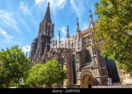 Ulmer Münster oder Ulmer Münster. Es ist ein berühmtes Wahrzeichen Ulms. Panorama der verzierten Fassade der gotischen Kirche im Sommer. Szenerie von mediev Stockfoto