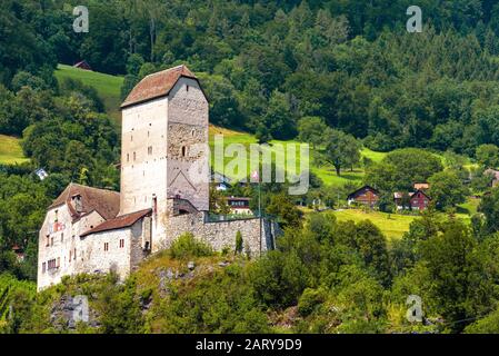 Schloss Sargans in Alpen, Schweiz. Sie ist das Wahrzeichen des Kanton St. Gallen. Malerische Aussicht auf die alte Burg auf dem Hintergrund von Bergwald und Dorf. Alpin Stockfoto