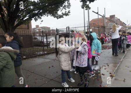 Grundschulkinder auf dem Bürgersteig außerhalb der Schule im multiethnischen, multikulturellen Viertel Kensington in Brooklyn, New York. Stockfoto