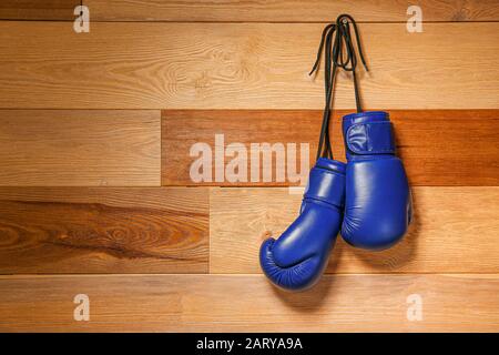 Zwei Boxhandschuhe hängen an der Holzwand Stockfoto