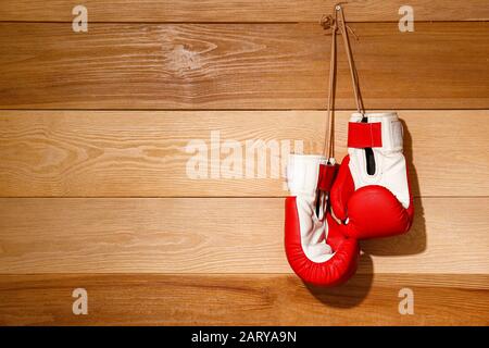 Zwei Boxhandschuhe hängen an der Holzwand Stockfoto