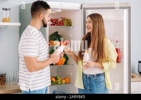Junges Paar, das Essen aus dem Kühlschrank in der Küche nimmt Stockfoto