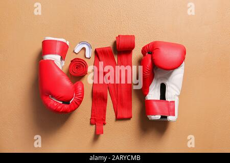 Boxhandschuhe, Handgelenkbänder und Mundstück auf Farbhintergrund Stockfoto