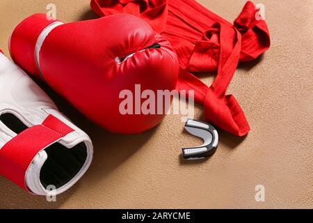 Boxhandschuhe, Handgelenkbänder und Mundstück auf Farbhintergrund Stockfoto