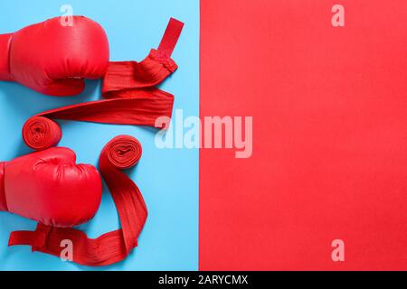 Boxhandschuhe und Armbänder auf Farbhintergrund Stockfoto