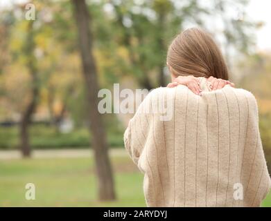 Junge Frau mit Rückenbeschwerden im Freien Stockfoto