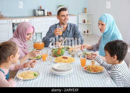 Muslimische Familie, die zu Hause zu Abend gegessen hat Stockfoto
