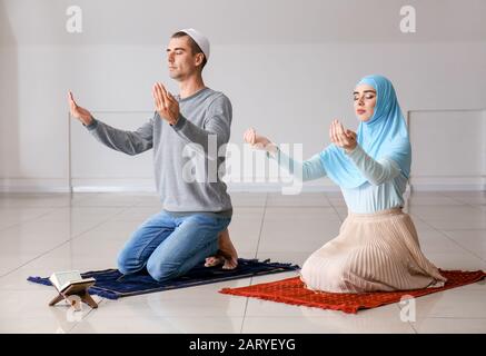 Muslimisches Paar betet im Zimmer Stockfoto