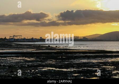 Die Skyline von Belfast, eine Skyline der Industrie, bei Sonnenuntergang über Belfast Lough an einem Herbstnachmittag mit Blick auf den Belfast Lough Vorshore in Holywood. Stockfoto