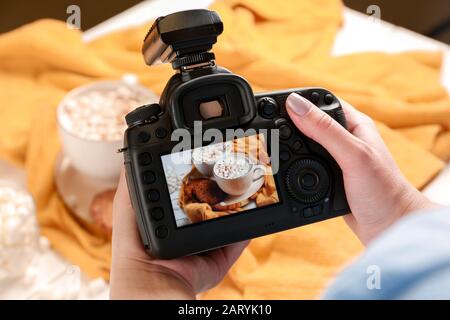 Fotografin fotografiert mit Marshmallows auf dem Tisch Stockfoto