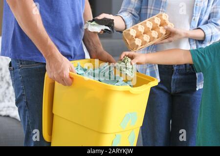 Familie und Container mit Müll zu Hause. Recycling-Konzept Stockfoto