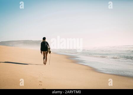 Frau Holding Surfbrett am Strand Stockfoto