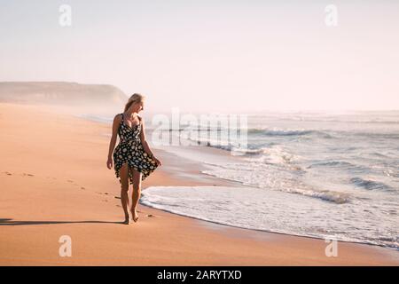 Frau in schwarzem Kleid am Strand Stockfoto