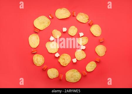 Leckere Kartoffelchips und Krabben-Stöcke auf Farbhintergrund Stockfoto