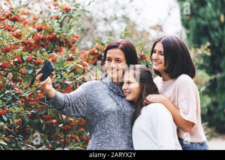 Mutter und Töchter lächeln und machen Selfie Stockfoto