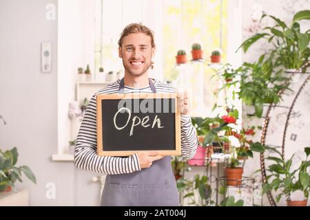 Portrait von männlichen Blumenhändler mit offenem Text im Laden Stockfoto