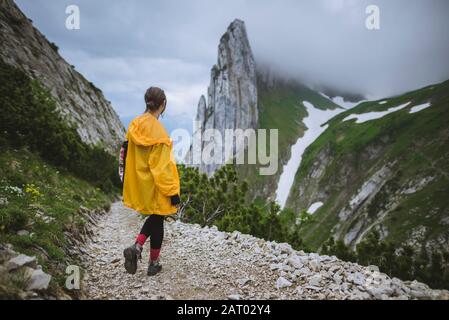 Frau in gelber Jacke bei Bergen in Appenzell, Schweiz Stockfoto