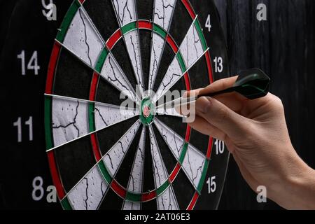 Junger Mann, der Darts spielt, in der Nähe Stockfoto