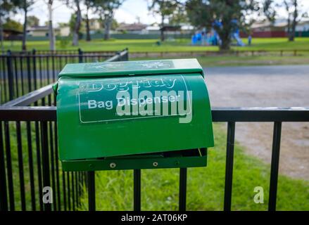 Dogtidy Bag Spender, leer und beschädigt, auf Hundeparkgeländer in NSW, Australien Stockfoto