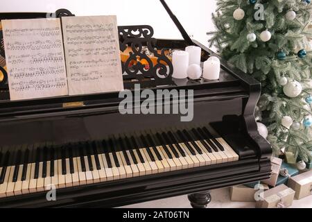 Grand Piano im Zimmer, das zu Weihnachten dekoriert ist Stockfoto