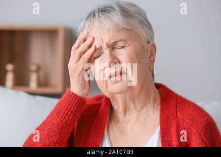 Ältere Frau mit Kopfschmerzen zu Hause Stockfoto