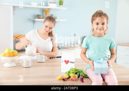 Kleines Mädchen mit Geschenke für ihre Mutter zu Hause Stockfoto