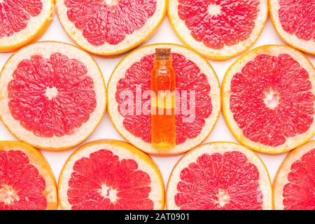 Flasche ätherisches Öl auf Grapefruitscheiben Stockfoto