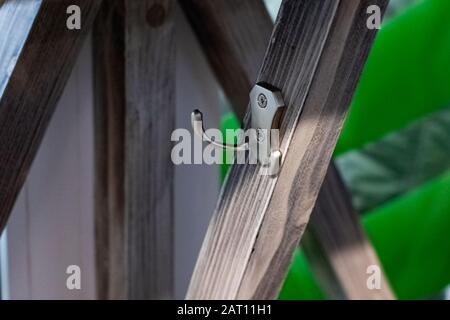 Die Kleidung ist an einer Wand aus Holz befestigt Stockfoto