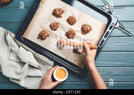 Frau backt zu Hause leckere Plätzchen mit Schokoladenchips Stockfoto