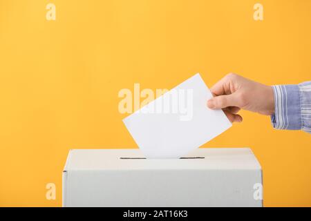 Wahlfrau in der Nähe der Wahlurne auf Farbhintergrund Stockfoto