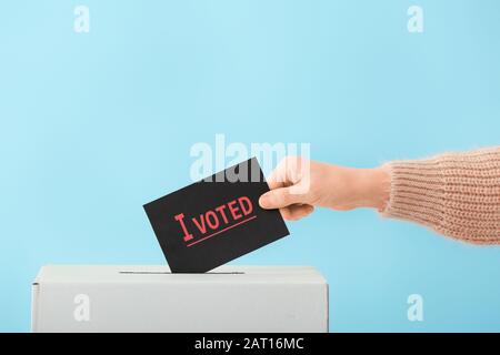 Wahlfrau in der Nähe der Wahlurne auf Farbhintergrund Stockfoto