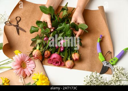 Blumenfrau macht schönen Blumenstrauß auf weißem Hintergrund Stockfoto