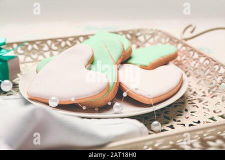 Platte mit leckeren herzförmigen Plätzchen auf Tablett, in der Nähe. Valentinstag gefeiert Stockfoto