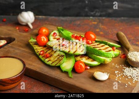 Gegrilltes Gemüse mit leckeren Tahini auf Holzbrett Stockfoto