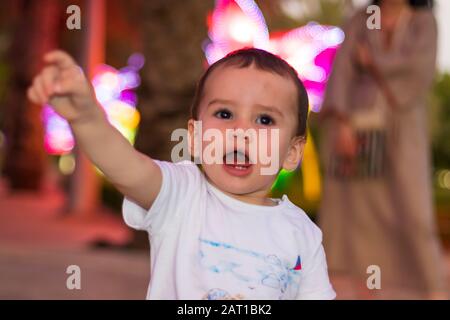 Ein süßes kleines Mädchen im Dubai Glow Garden am Abend. Stockfoto