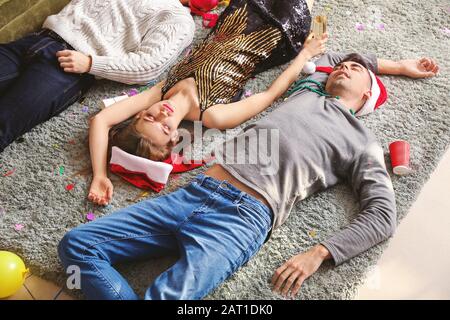 Betrunkene Freunde schlafen nach Neujahrsfeier zu Hause Stockfoto