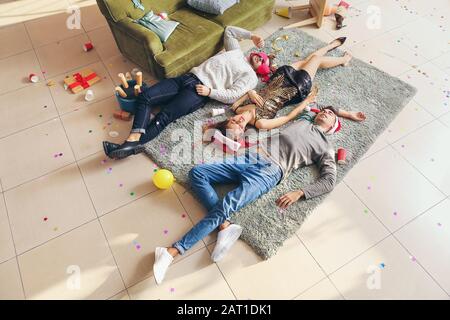 Betrunkene Freunde schlafen nach Neujahrsfeier zu Hause Stockfoto