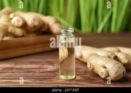 Flasche mit Ingweröl auf Holztisch Stockfoto
