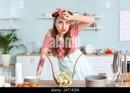 Lustige mütige Hausfrau in der Küche Stockfoto