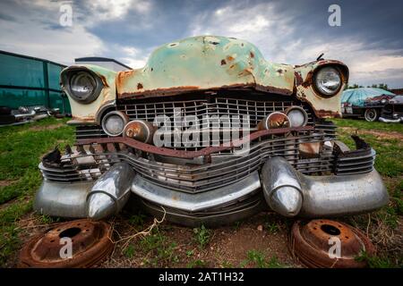 Nahaufnahme einer verrostenen alten Oldtimer-Front, die mit zerbrochenen Teilen im Junkyard aufgegeben wurde Stockfoto