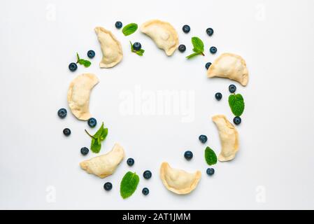 Rahmen aus rohen Knödel mit Blaubeeren auf weißem Hintergrund Stockfoto