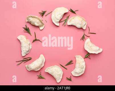 Rahmen aus rohen Knödel mit Kräutern auf Farbhintergrund Stockfoto