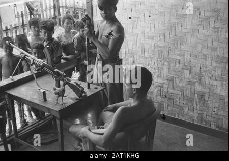 Banjoemas, Chinesische Kontrollkommission. Hafen von Tjilatjap. Waranedja Waranedja: Soldat Asmita und Soldat Ikim von der 1. Platte 3. Compie Andjing Nica, beide Sundanesen, die Bren reinigen nicht das Interesse der Lagerjugend. Datum: 10.Oktober 1947 Ort: Indonesien, Niederländisch-Ostindien Stockfoto