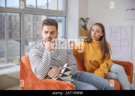 Junge Frau, die versucht, mit Mann Frieden zu schließen, nachdem sie zuhause Streit hatte Stockfoto