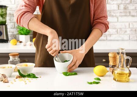 Frau bereitet in der Küche gesunde Pesto-Sauce zu Stockfoto