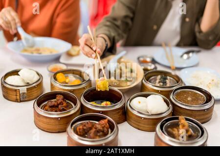 Hände mit Essstäbchen mit gedämpften Knödel dimmen Sum Essen im Restaurant. Stockfoto