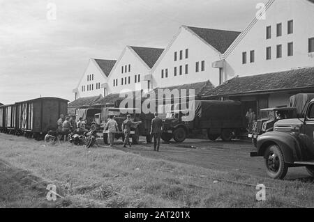 Lebensmittel-Goodsangs [Lagerhallen] des Generalquartiermeisters Exterior of the Good-angs. Vor LKWs und Zugwaggons Datum: März 1947 Standort: Batavia, Indonesien, Jakarta, Niederländisch-Ostindien Stockfoto