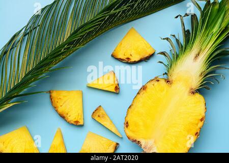 Frisch geschnittene Ananas und Palmblatt auf Farbhintergrund Stockfoto