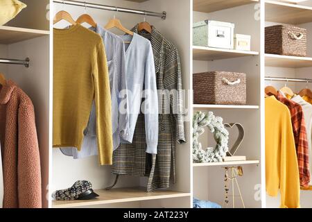 Moderner kleiderschrank mit modischer Winterkleidung und Accessoires Stockfoto