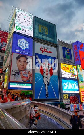 Osaka, JAPAN - 14. OKTOBER 2019: Die hellen und blitzigen Plakate entlang des Dotonbori-Kanals mit dem Symbol der Stadt, der Glico Running Man in der Nähe Stockfoto